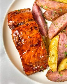 a white plate topped with meat and potatoes