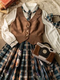 A strap skirt, vest and blouse with a picture of a cat innocently playing with a persimmon. The color of the skirt has a cute retro feel to it. Tighten the included necktie to complete a casual and elegant literary girl. strap skirt Vest (light brown/dark brown) blouse strap skirt small size Total length: 72cm Waist: 54-68cm medium size Total length: 72cm Waist: 60-74cm L size Total length: 72cm Waist: 66-80cm XL size Total length: 72cm Waist: 72-86cm XXL size Total length: 72cm Waist: 78-92cm v Dark Brown Blouse, Dark Academia Outfits, Strap Skirt, Academia Outfits, Beige Vest, Old Fashion Dresses, Brown Blouse, Look Retro, Neue Outfits