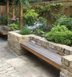 a wooden bench sitting in the middle of a garden