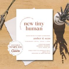 an image of a new tiny human baby shower card on a wooden table with flowers