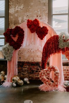 a valentine's day display with flowers and balloons in the shape of two hearts