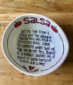 a bowl with writing on it sitting on top of a wooden table