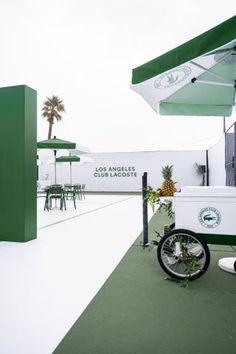 an ice cream cart sitting on top of a green and white floor next to a building