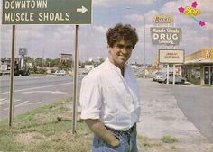 a man standing in front of a street sign