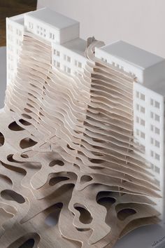 a model of a building made out of wooden planks and plywood strips with holes in the middle