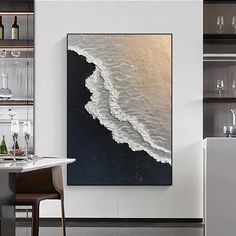 an abstract painting on the wall above a dining room table with wine glasses and bottles