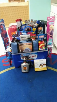 a blue luggage cart filled with lots of toys and other items sitting on top of a blue rug