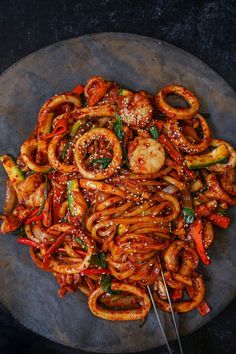 a plate full of stir fry noodles with shrimp and vegetables in sauce on the side