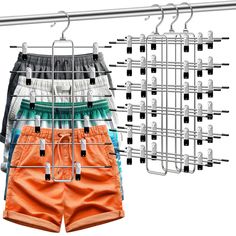 an assortment of men's shorts hanging on a clothes rack with clips to hang them