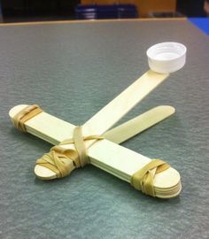 a pair of wooden spoons sitting on top of a table next to a cup