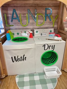 a washer and dryer sitting in front of a laundry sign on the wall