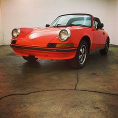 an orange sports car parked in a garage