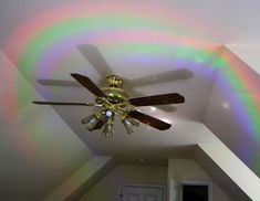 a ceiling fan in a room with a rainbow light