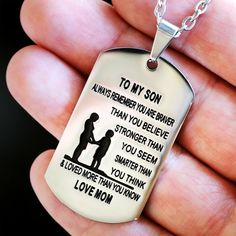 a hand holding a dog tag that says to my son