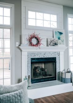 a living room with a fire place and pictures on the fireplace mantel above it