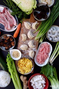 an assortment of food is laid out on a table with chopsticks and bowls