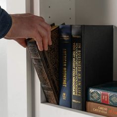 a person is reaching for books on a shelf