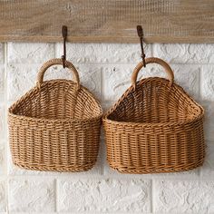 two wicker baskets hanging on a brick wall