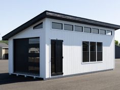 a small white building sitting on top of a tarmac next to a parking lot