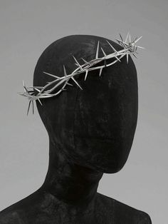 a black mannequin head with a crown of thorns on it's head