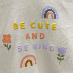 a white t - shirt with the words be cute and be kind written on it