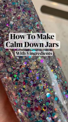 a hand holding a bottle with glitter on it and the words how to make calm down jars