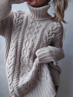 a woman wearing a white turtle neck sweater