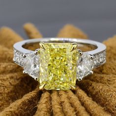 a fancy yellow diamond ring with three white diamonds