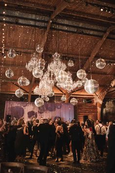 a group of people that are standing in the middle of a room with chandeliers hanging from the ceiling