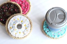 three crocheted donuts sitting on top of each other next to a coffee cup