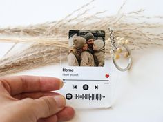 a hand holding a keychain with an image of two people on it