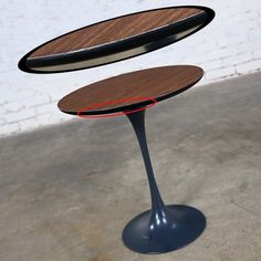 two wooden tables sitting on top of each other in front of a white brick wall