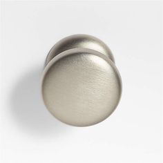 two metal knobs on a white surface