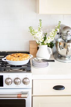 a white stove top oven sitting in a kitchen next to a pot filled with food