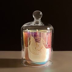 a glass jar with a candle inside on a table