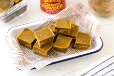 several pieces of peanut butter fudge sitting on top of a paper towel next to a jar of peanut butter