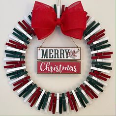 a christmas wreath with red bows and merry sign