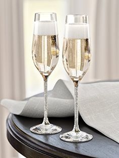 two champagne flutes sitting on top of a table