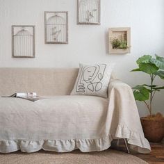 a living room with a couch, rug and pictures on the wall above it that have birdcages in them