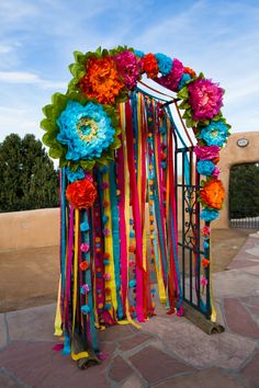 an arch decorated with colorful ribbons and flowers