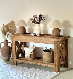 a wooden table topped with vases and lamps