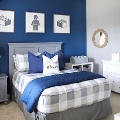 a bedroom with blue walls and pictures on the wall above the bed, along with two nightstands