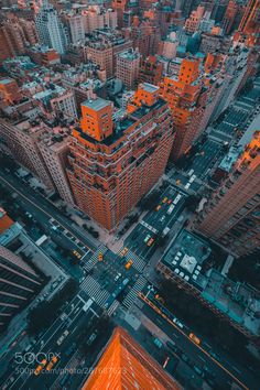 an aerial view of the city at night with orange lights and tall buildings in the background