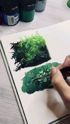 a person is drawing on paper with colored pencils and watercolor paints in front of them