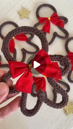 someone is holding an ornament made out of yarn and ribbon with bows on it