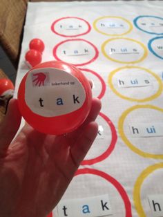 a person holding up a red object with words on it in front of a table