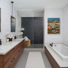 a bathroom with a large bathtub next to a walk in shower and two sinks