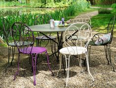 an outdoor table with four chairs around it