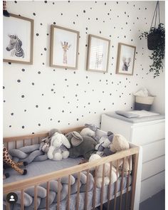 a baby crib with stuffed animals and pictures on the wall