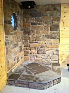 a bathroom with a stone shower and wooden walls